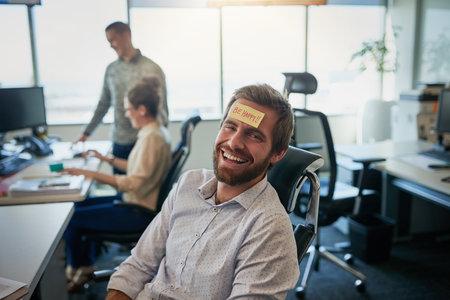 Is there something on my forehead. a cheerful young businessman with a sticky note on his forehead...