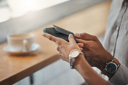 Contactless payment, NFC technology and tapping a bank or credit card for payment at a coffee shop,...