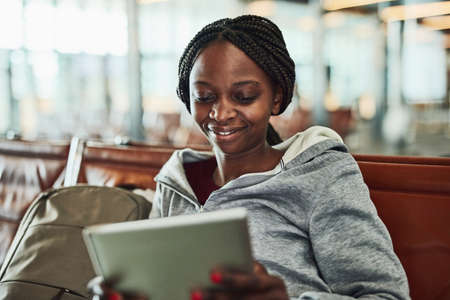 No wait is too long with the right entertainment. a young woman using her digital tablet at the...