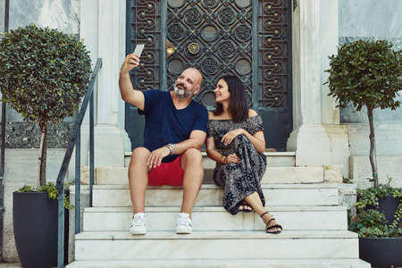 Never miss a selfie moment. an affectionate couple taking a selfie while spending time together outdoors.の写真素材