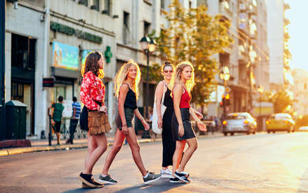 City slickers on the move. Full length shot of a group of attractive young girlfriends taking a walk through the city.の写真素材