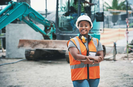 Happy woman construction worker with a ready to work smile on a job site outside. Portrait of a proud young building development manager about to start working on engineering industrial plansの写真素材