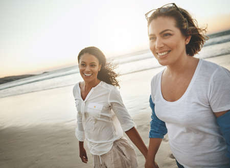 The beach is the perfect place to be yourself. a loving couple walking hand in hand on the beach.
