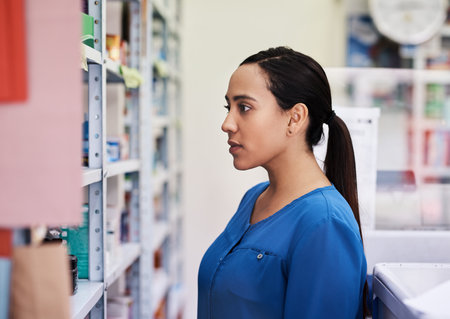 I have to make sure I choose the correct meds. a young woman shopping at a pharmacy.の写真素材