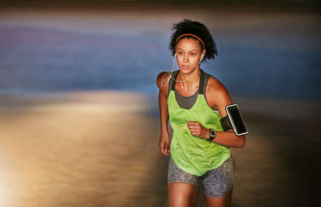 Find it inside yourself to just keep pushing on. a sporty young woman out for a run.の写真素材