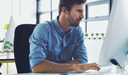 Dont wish for it, work for it. a handsome young businessman working on a computer in the office.