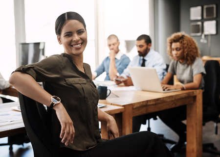 This is where we make success happen. Portrait of a young businesswoman sitting in an office with...