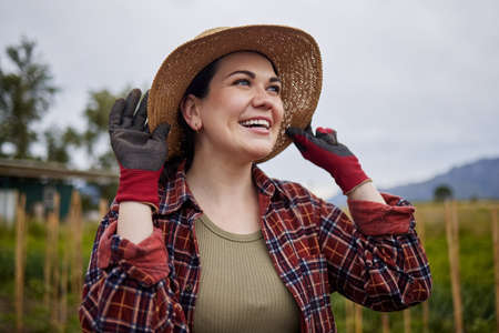 Happy agriculture farmer woman on farm checking clouds sky for outdoor farming, gardening and...