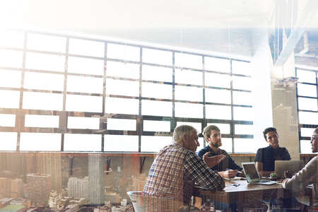 Working hard to become the best in the city. Multiple exposure shot of businesspeople having a...