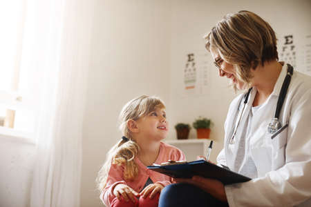 I enjoy working with kids. a doctor having a consultation with a little girl in her consulting room.