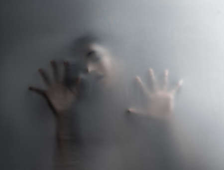 You cannot escape. an unrecognizable woman trapped behind a hazy film.