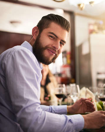 I enjoy our family lunches. Cropped portrait of a handsome young man eating during a family dinner at home.の写真素材