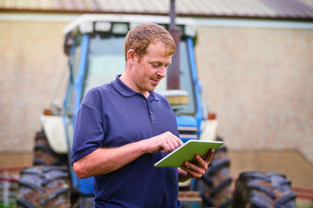 The smart farmer. a farmer using a digital tablet on his farm.の写真素材