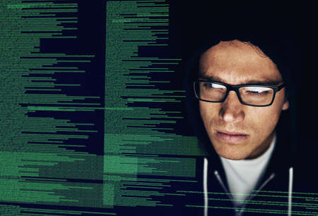 Soon all your information will be mine. a young hacker cracking a computer code in the dark.