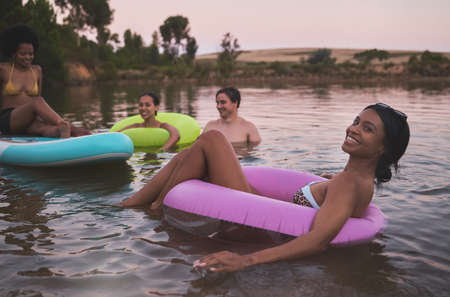 Vacation, swimming and friendship having fun in a lake while enjoying the summer sunset. Happy...