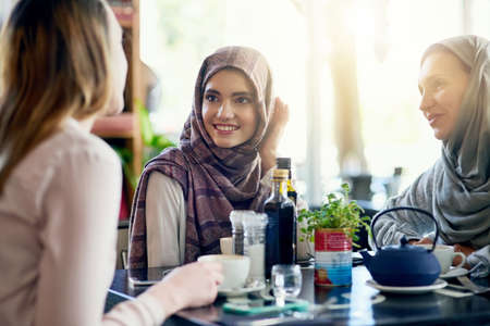 Catching up with the girls is always a good idea. a group of women chatting over coffee in a cafe.