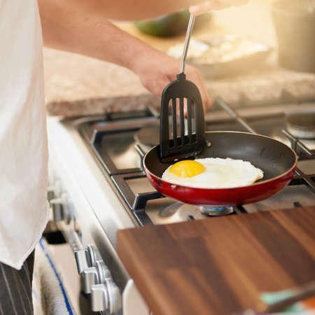 Theres nothing eggs cant do to help kickstart your morning. a young man preparing breakfast at home.の写真素材
