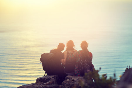 Enjoy the small luxuries in life. a group of friends on a mountain top.の写真素材