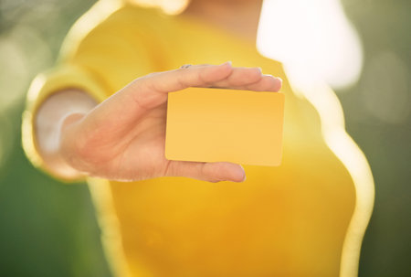 The newest credit card on the market. an unrecognizable young woman holding a credit card.の写真素材