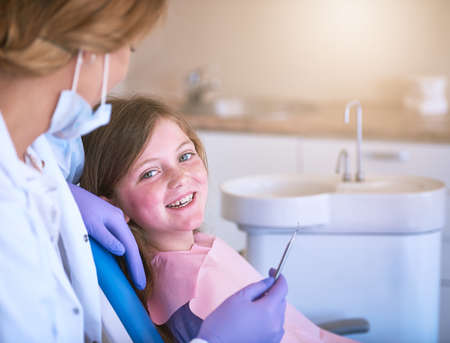 Shes perfectly at ease. a dentist examining a little girls teeth.の写真素材