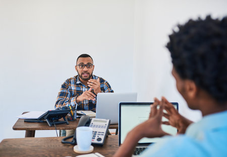 Passionate about his plans for their startup. two young coworkers having a discussion opposite each...