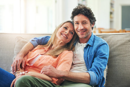 She fills my heart with so much love. Portrait of a happy mature couple relaxing together on the sofa at home.の写真素材