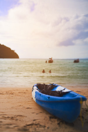 Ready to hit the water. a single canoe on the shore of a tropical beach.の写真素材