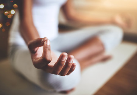Mindful meditation. an unrecognizable young woman practicing yoga indoors.の写真素材
