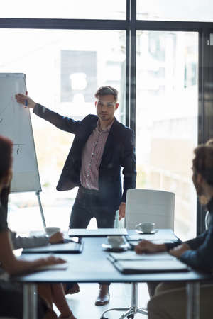 Im excited about these prospects. a well dressed businessman giving a presentation to his colleagues in the boardroom.の写真素材