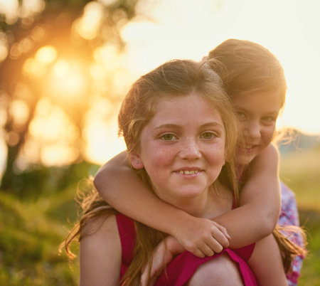 The love of a sister lasts forever. Portrait of two cute sisters playing together in the park.の写真素材