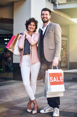 Everyone loves a man with patience. a couple out on a shopping spree.の写真素材