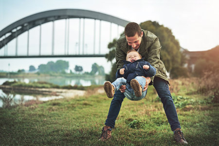 Sharing playtime together. a father bonding with his son outside.の写真素材