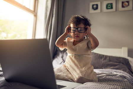 Growing up in the age of technology. Full length portrait of an adorable little girl using a laptop...