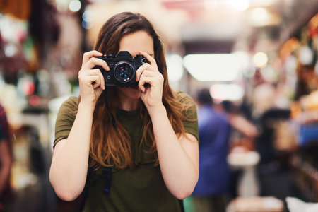Hold still. Portrait of an unrecognizable young woman taking a photo at the screen while standing at...