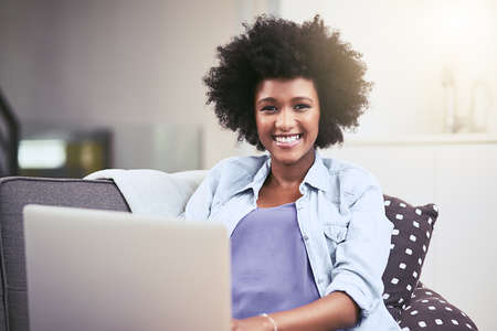 I prefer to browse at leisure. a young woman using a laptop on the sofa at home.