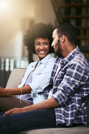 Nothing wrong with a sofa date. a young couple relaxing together on the sofa at home.の写真素材