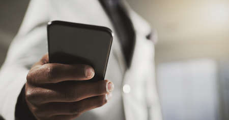 Online is where success is at. Closeup shot of an unidentifiable businessman using a cellphone in an...