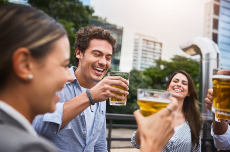 Celebrating yet another successful week. businesspeople having drinks on their office balcony.の写真素材