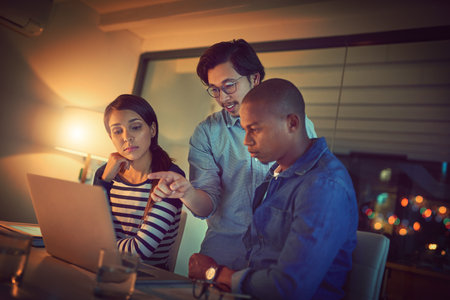 That right there could be our solution. a group of designers working late in an office.の写真素材