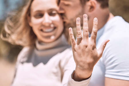 Closeup hand of proposal engagement ring after romantic, caring and loving man proposes to woman. Happy, smiling and excited couple showing wedding band while hugging, embracing or holding each otherの写真素材