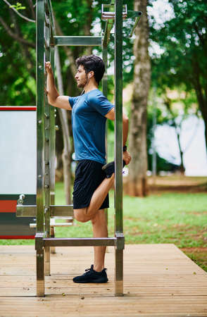 Getting into shape requires strong determination. a sporty young man stretching his legs while...