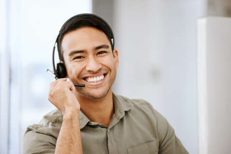 Smiling, friendly call center agent with headset for online consulting in an IT tech agency. Face of...