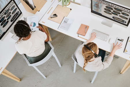 Marketing strategy, customer service and female office team working on a computer indoors. Female advertising staff planning a web work research project together with headsets insideの写真素材