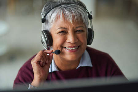 Helpful advice is just a call away. Portrait of a mature woman working in a call centre.