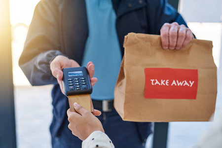 Your food has arrived. an unrecognizable delivery man receiving payment from a female customer for...
