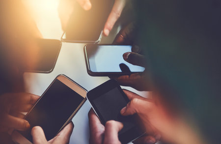 Do you know whos in your network. a group of people using their phones together.の写真素材