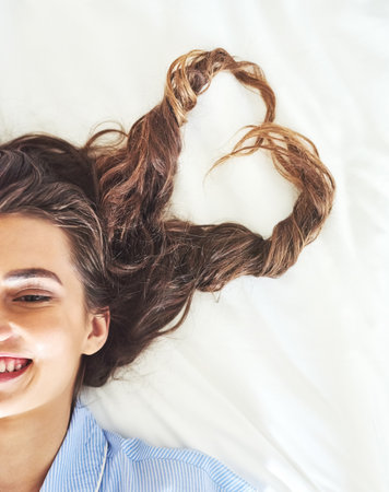 Blissful mornings. High angle shot of an attractive young woman relaxing on her bed.の写真素材