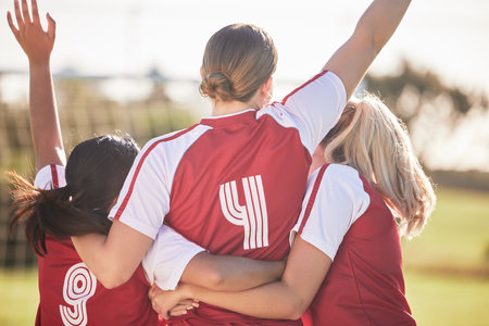 Female football team celebrating winning, goal or teamwork effort at a game, tournament or during...