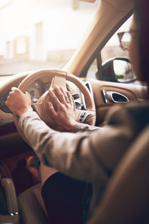 Get a move on. an unidentifiable businesswoman pressing the hooter while driving a car.