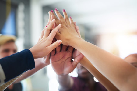 Heres to another successful study session. a group of unidentifiable friends high fiving each other...